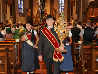 Zunftvater Rupert Reindl mit Zunftkreuz und Marketenderinnen beim Auszug aus der Kirche 2020